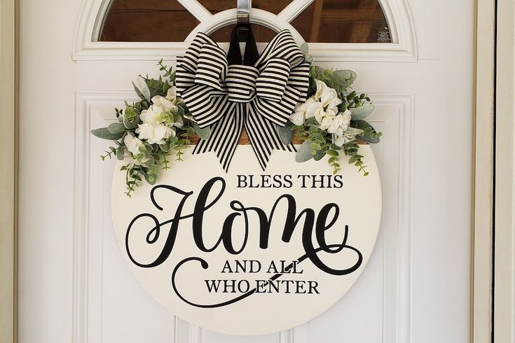 a white door with a black and white sign that says, bless this home and all who enter