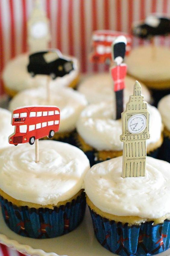 cupcakes with white frosting and decorations in the shape of london, england