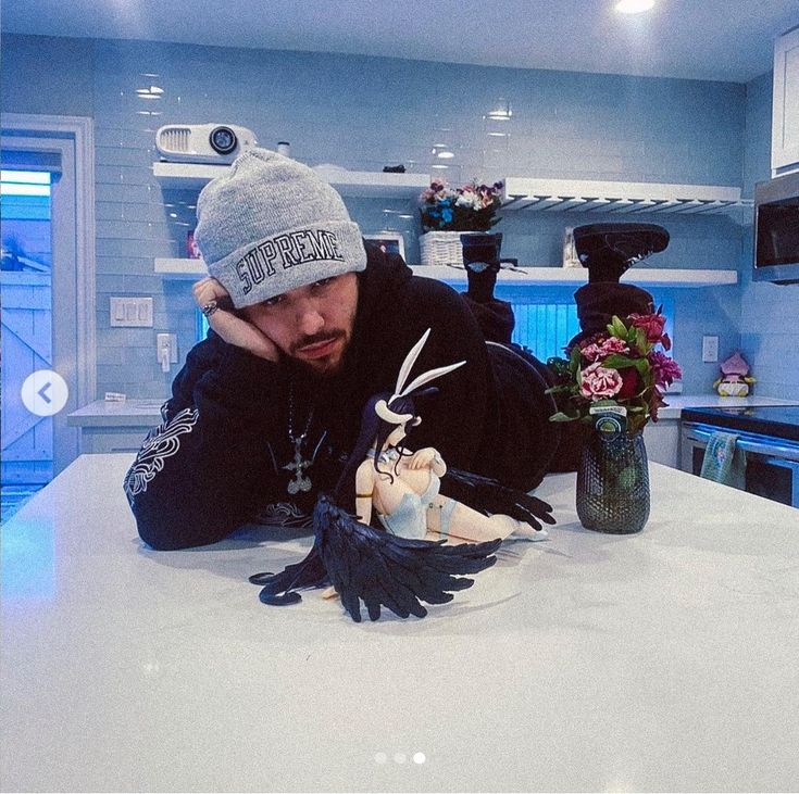 a man sitting at a kitchen counter with his hands on the top of a doll