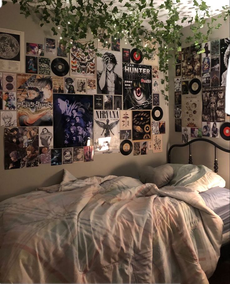 an unmade bed in a bedroom with lots of pictures on the wall above it