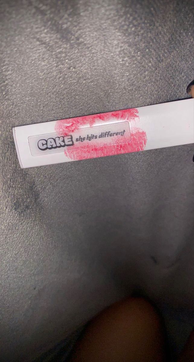 someone holding up a sticker that says cake on it