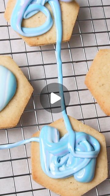 cookies with blue icing are on a cooling rack