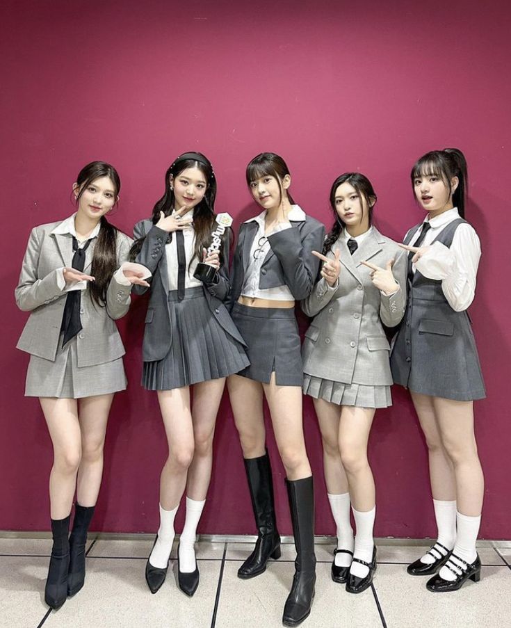 four girls in school uniforms posing for the camera