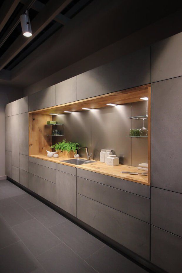 a kitchen with wooden counter tops and stainless steel cabinets, along with potted plants