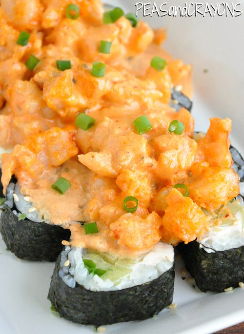 some sushi with sauce and green onions on it