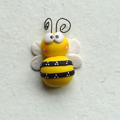 a yellow and black bee on white surface with one eye open, the other closed