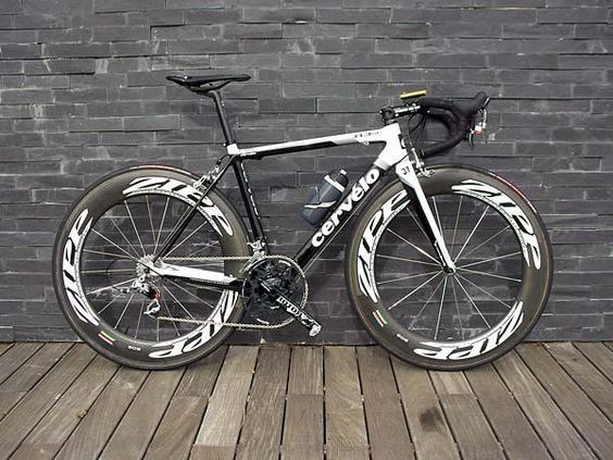 a bike parked on top of a wooden floor next to a brick wall