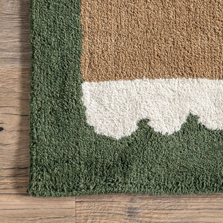 an area rug with green, brown and white colors on the wood floor next to a pair of scissors