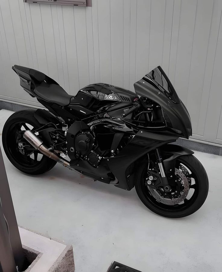 a black motorcycle is parked in a garage