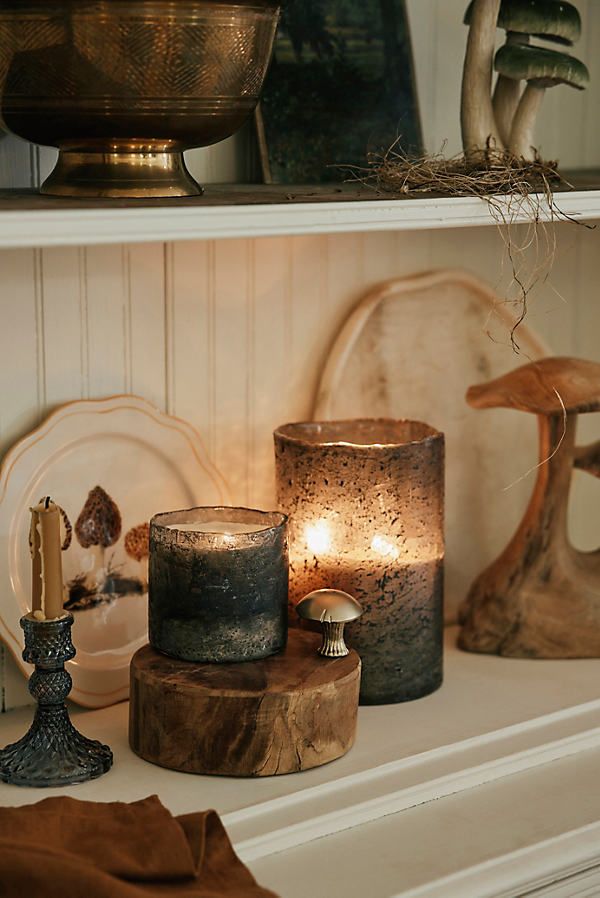 some candles are sitting on a shelf next to other items