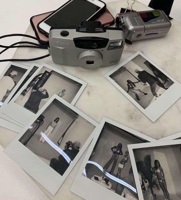 a camera and some polaroid pictures on a table