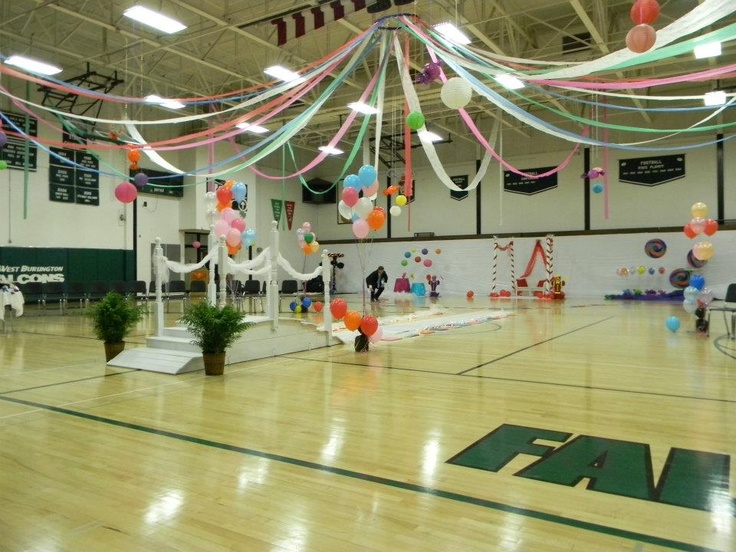 an indoor basketball court decorated with balloons and streamers