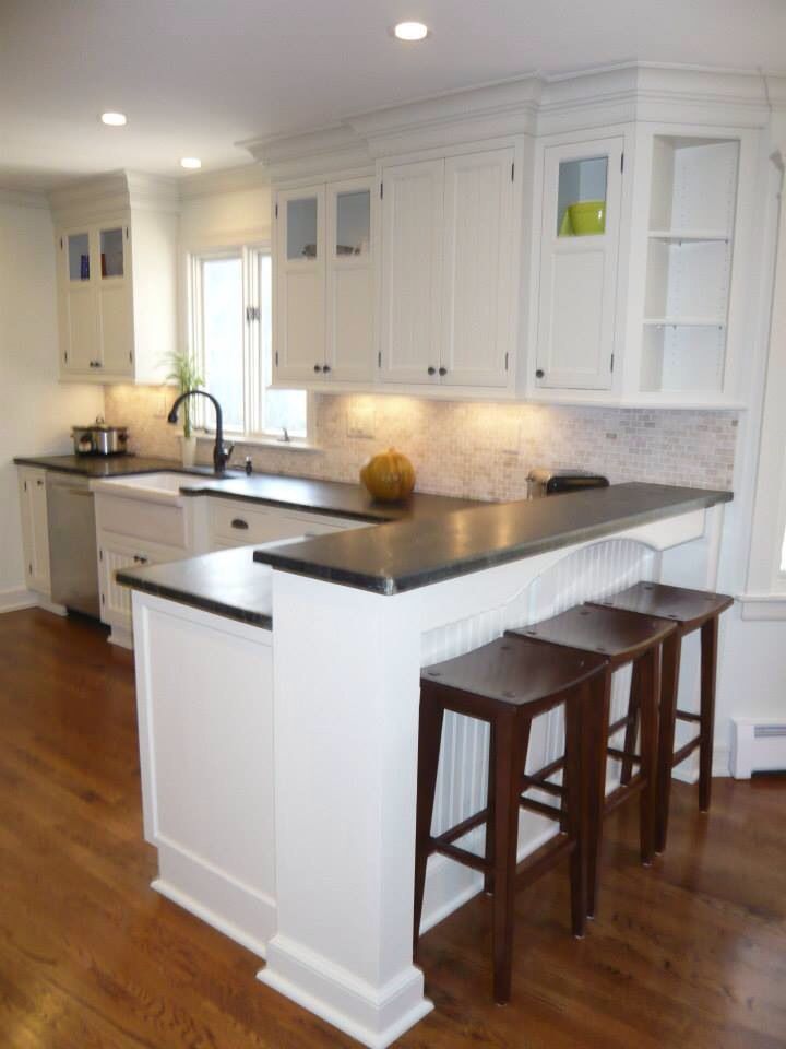 a kitchen with two stools next to an island