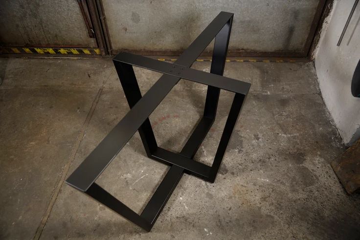 a metal object sitting on the ground in a room with concrete walls and flooring