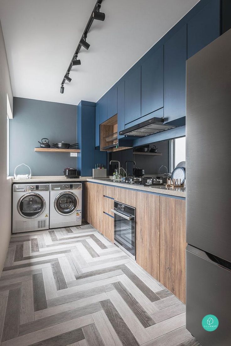 a kitchen with blue walls and wooden cabinets, an oven, washer and dryer