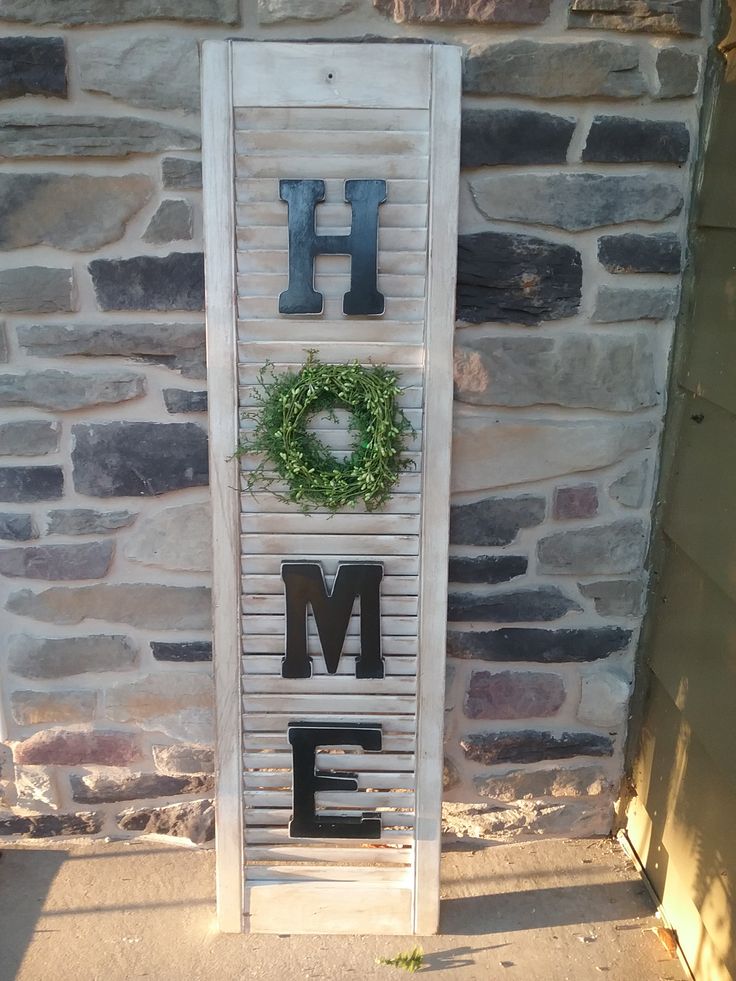 a sign that says home with a wreath on it