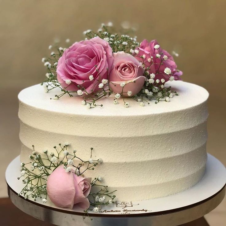 there is a white cake with pink flowers on it