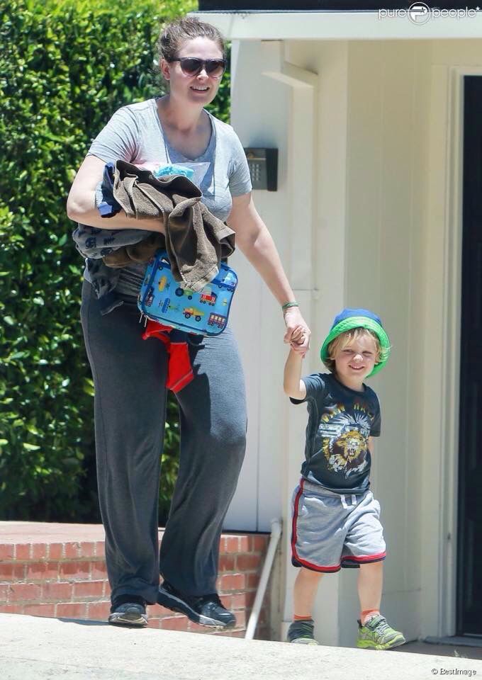 a woman holding the hand of a small boy