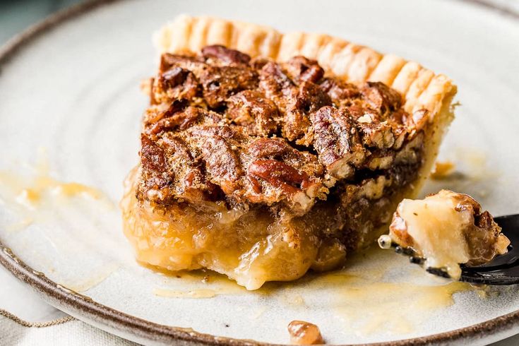 a piece of pecan pie on a plate with a fork