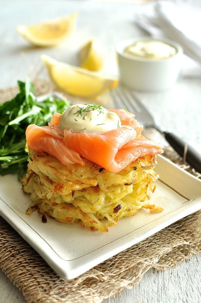 a stack of food sitting on top of a white plate next to a knife and fork