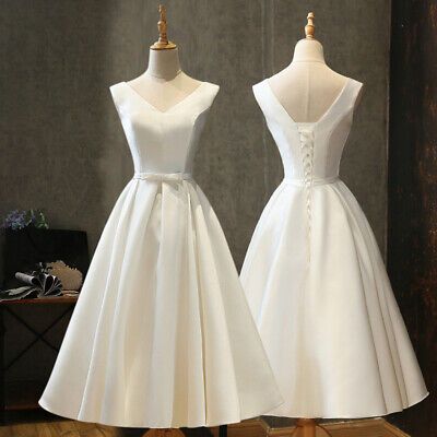 two white dresses on mannequins in front of a mirror