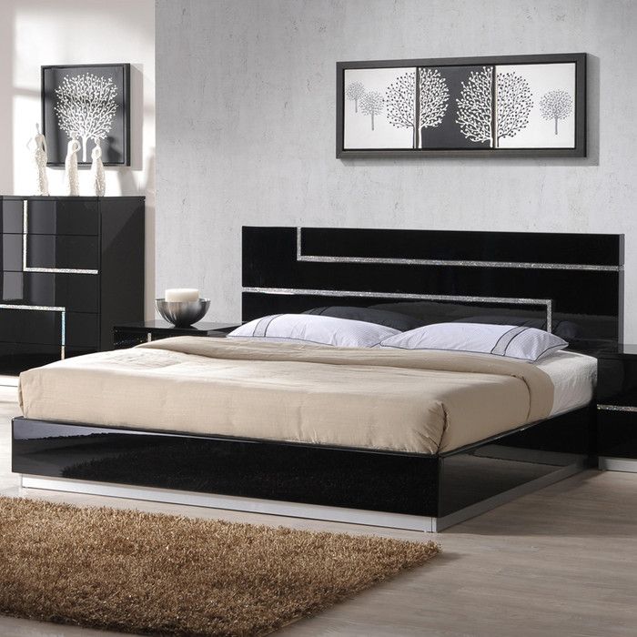 a bedroom with white walls, black furniture and carpeted flooring is pictured in this image