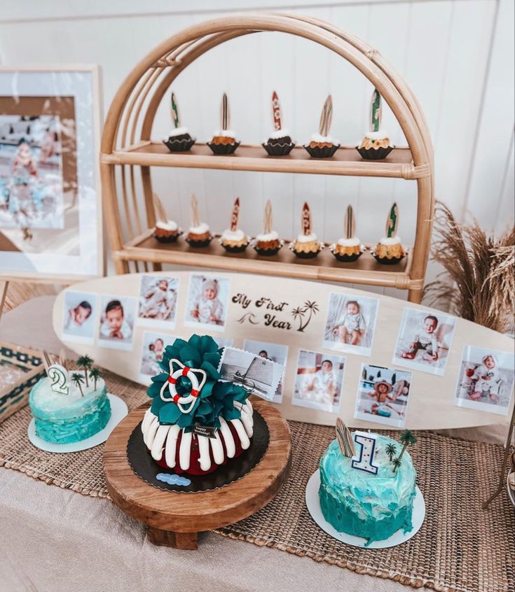 a table topped with cakes and cupcakes on top of a wooden tray covered in photos