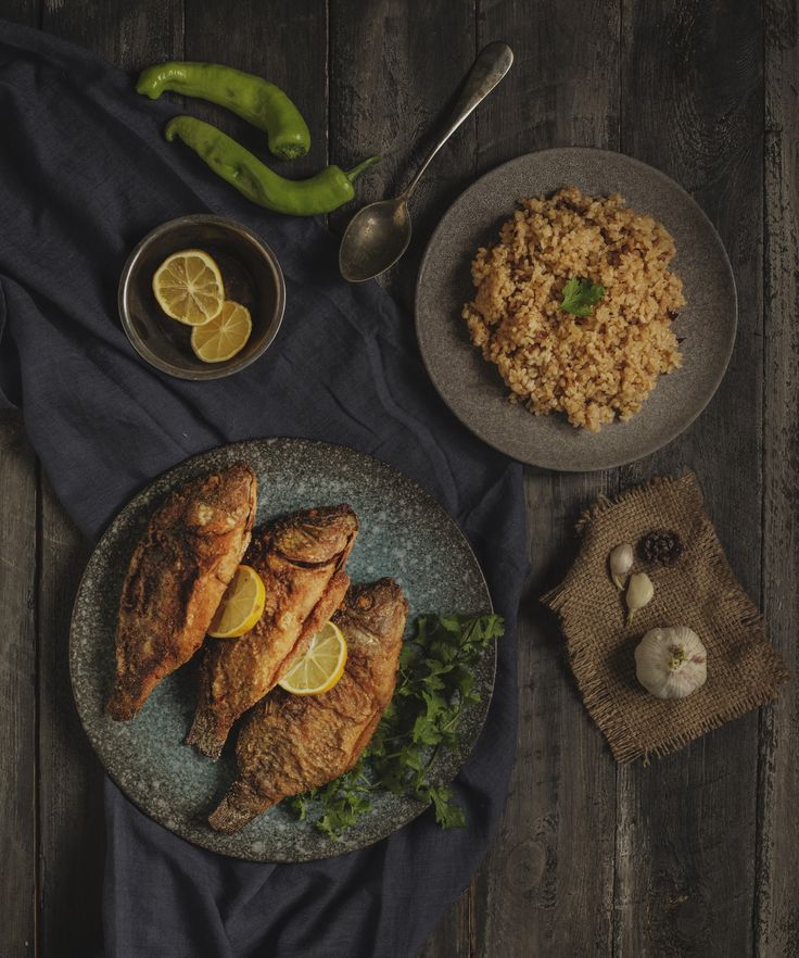 two plates with chicken, rice and vegetables on them