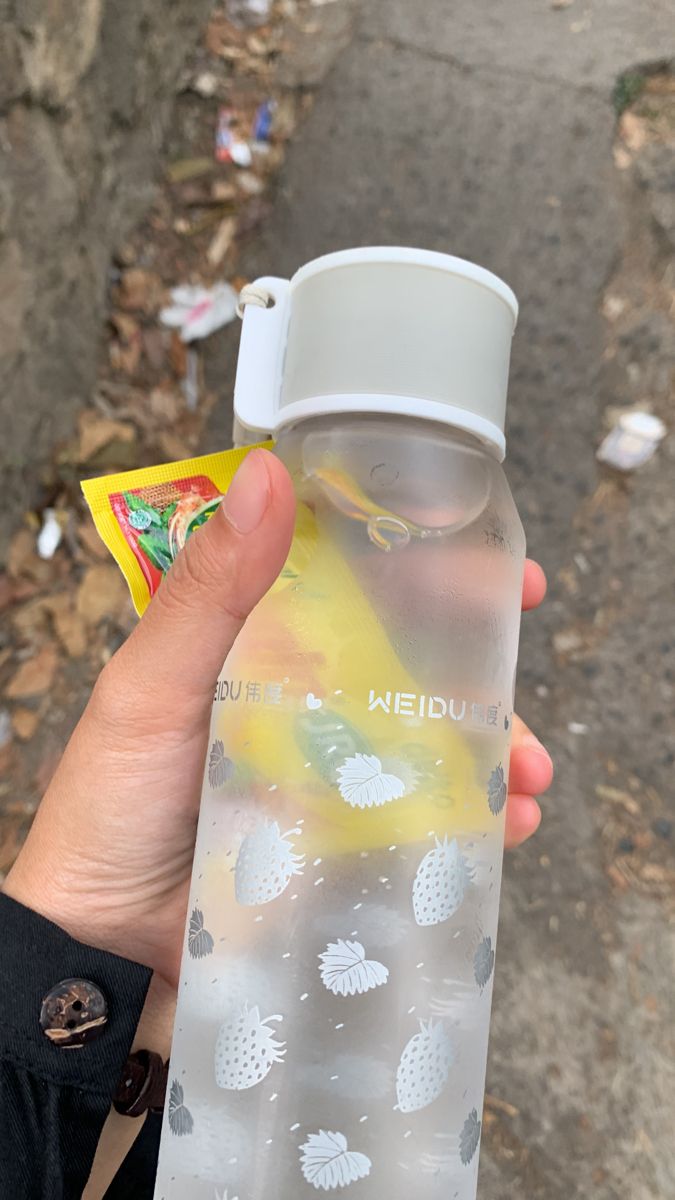 a person holding a plastic water bottle in their hand