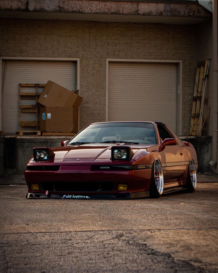 a red sports car parked in front of a garage