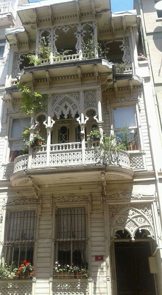 an ornate building with balconies and flowers on the balcony