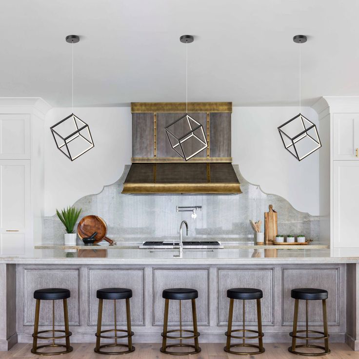 a kitchen with an island and four stools in front of the countertop area