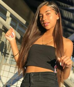 a woman with long brown hair wearing a black top