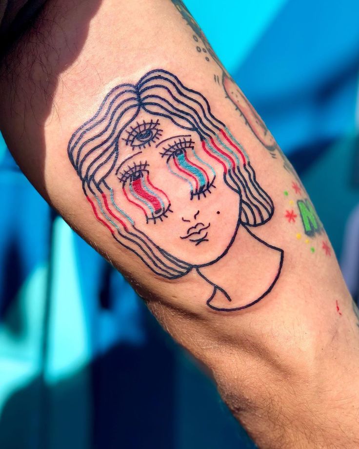 a man with a tattoo on his arm that has a woman's face painted on it