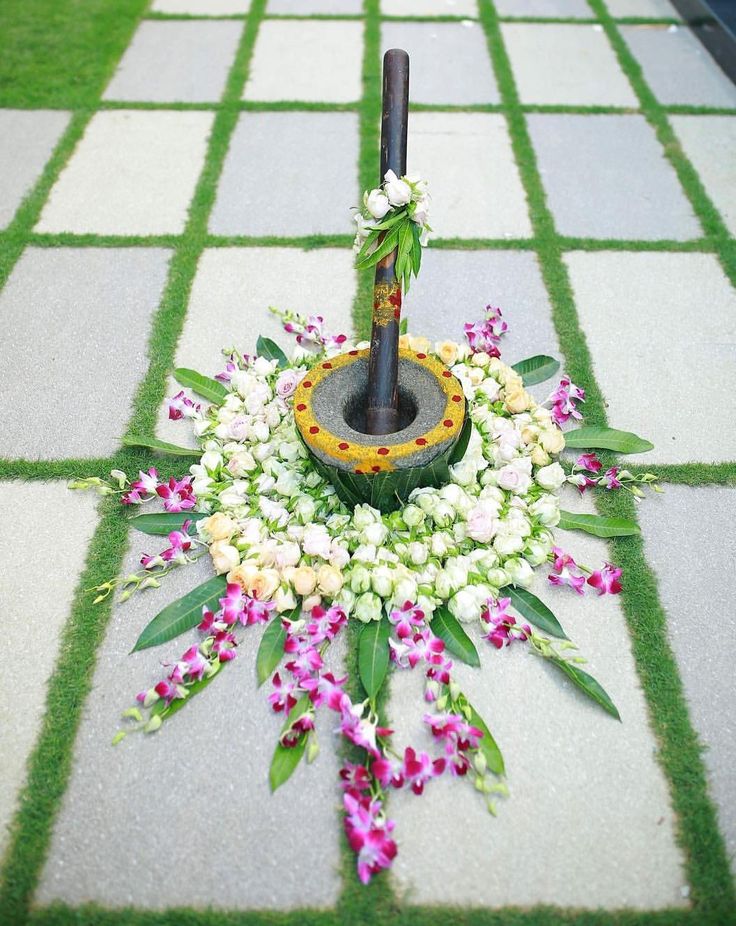 a flower arrangement on the ground with an umbrella in it's center and flowers around it