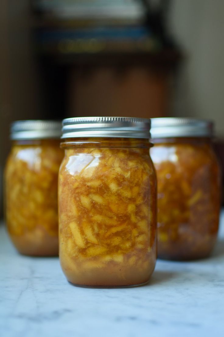 three jars filled with food sitting on top of a counter