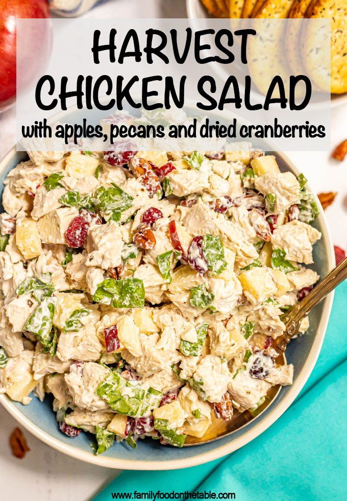 a bowl full of chicken salad with apples, peas and dried cranberries in it