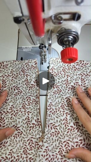 someone is using a sewing machine to sew something on a piece of fabric that has been printed with leaves