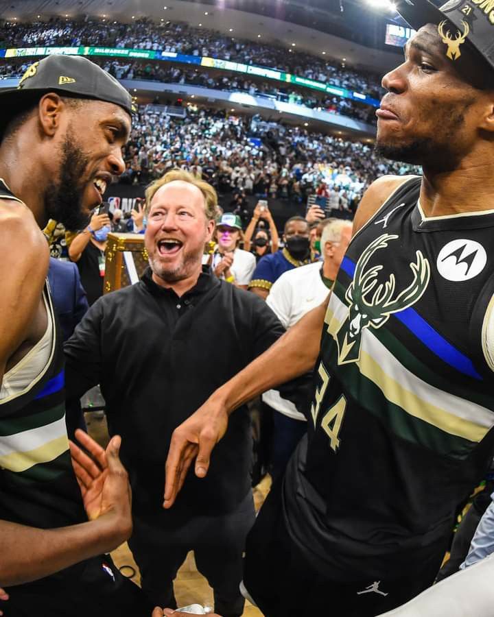 two men standing next to each other at a basketball game