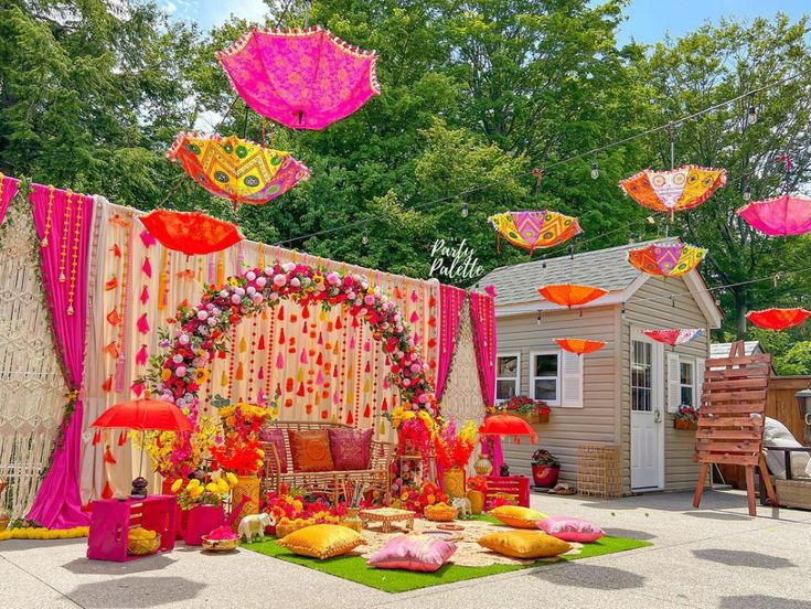 an outdoor wedding setup with pink and yellow umbrellas