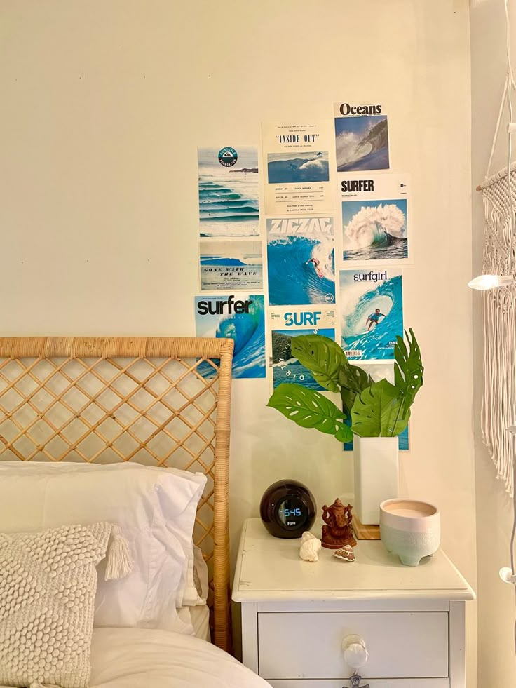 a white bed sitting next to a nightstand with a plant on top of it