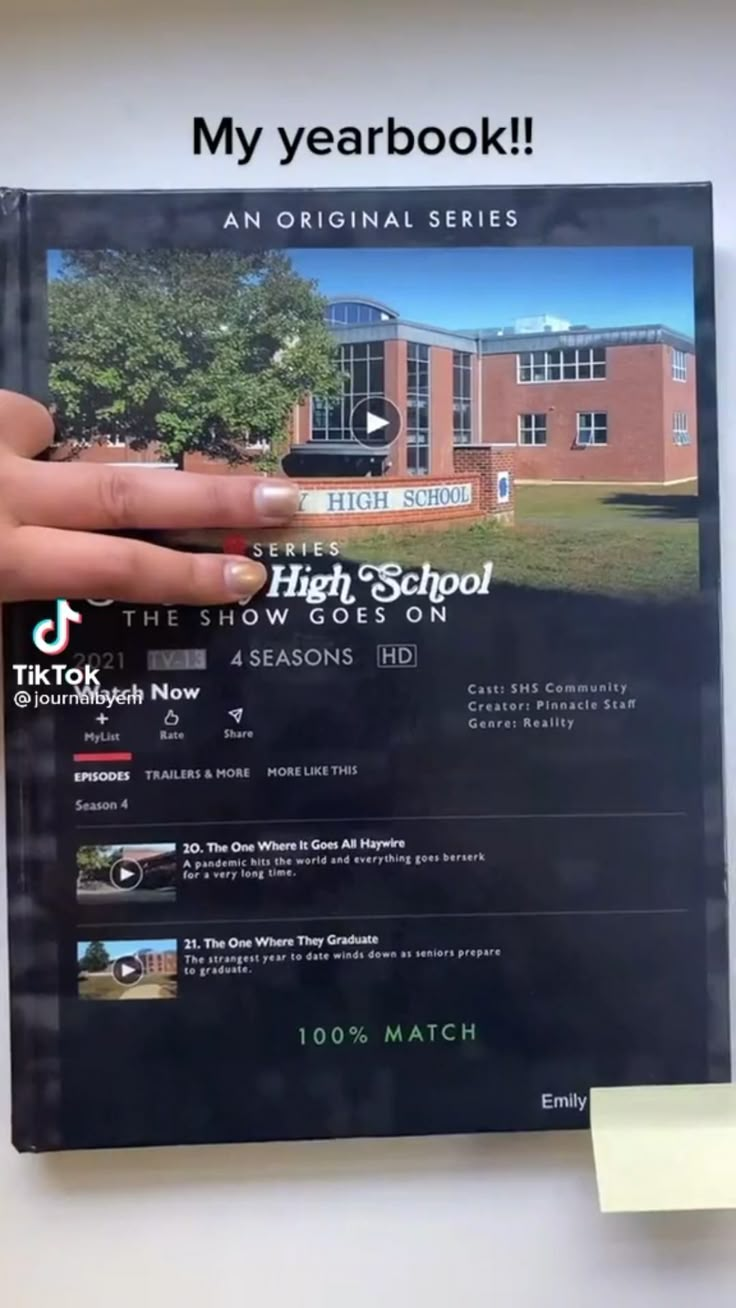 a person holding up a brochure with the words high school on it in front of a building