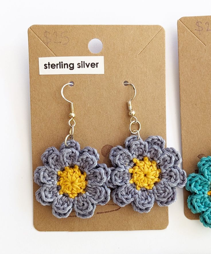 two crocheted flower earrings sitting next to each other on top of a card