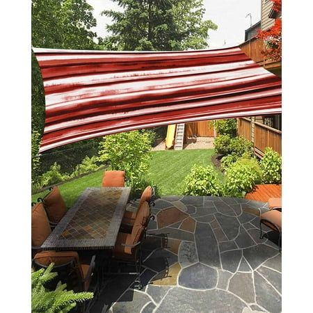 an outdoor dining area with table and chairs under a large red awning over it