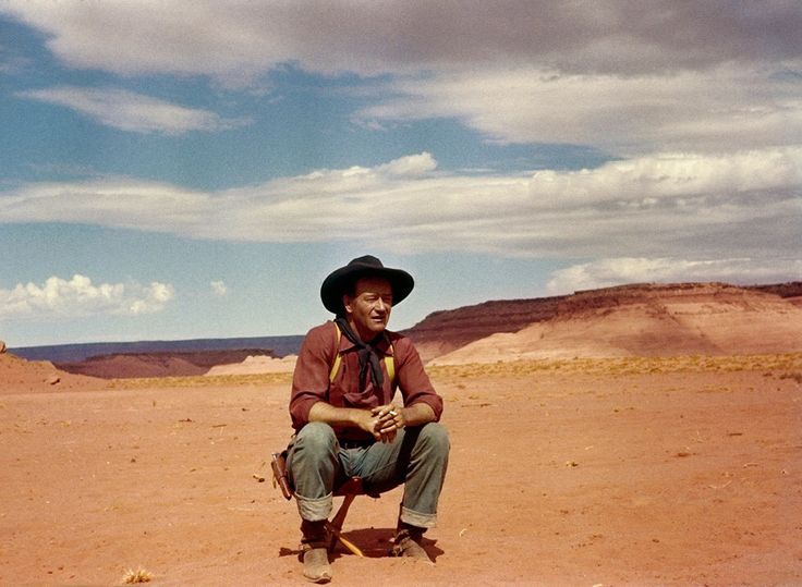 a man sitting on top of a dirt field