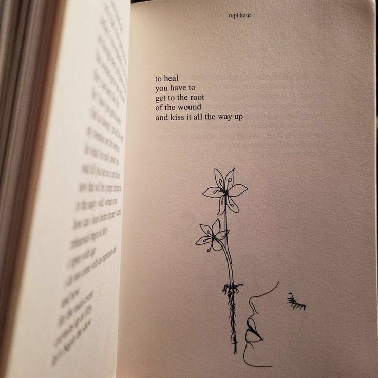 an open book with a drawing of a flower on the page and some words written in it