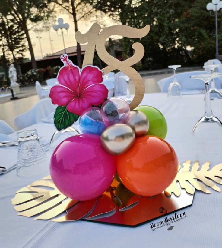 a table topped with balloons and a cake topper in the shape of a number