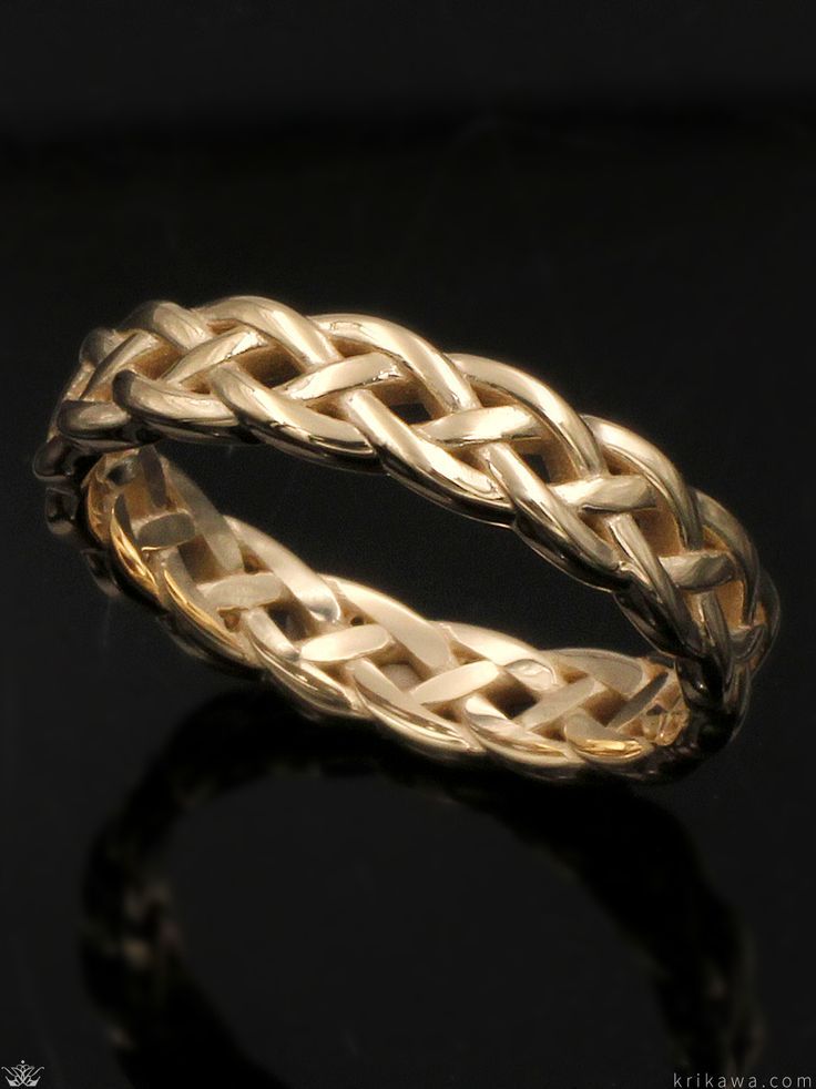 a gold braided ring on a black surface