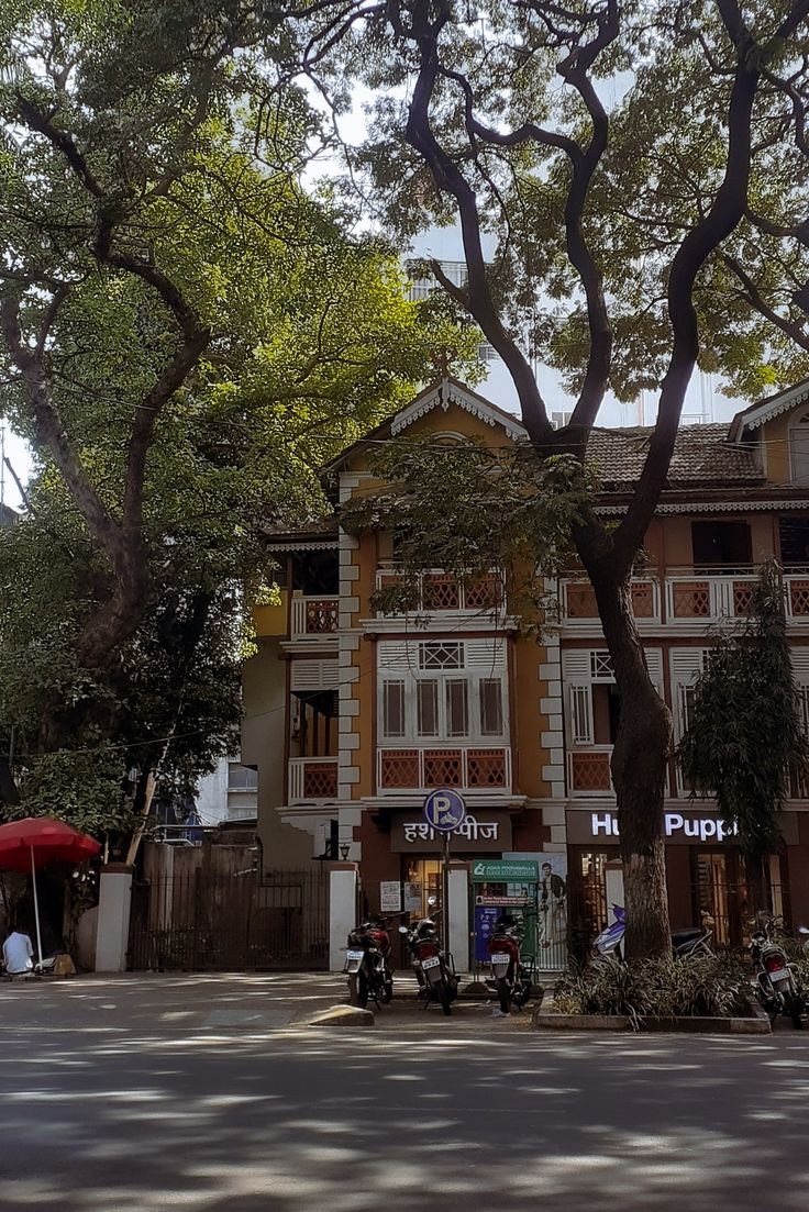 an old building with many balconies on the top floor and trees in front of it