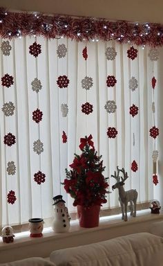 a living room window decorated for christmas with red and white decorations on the windowsill